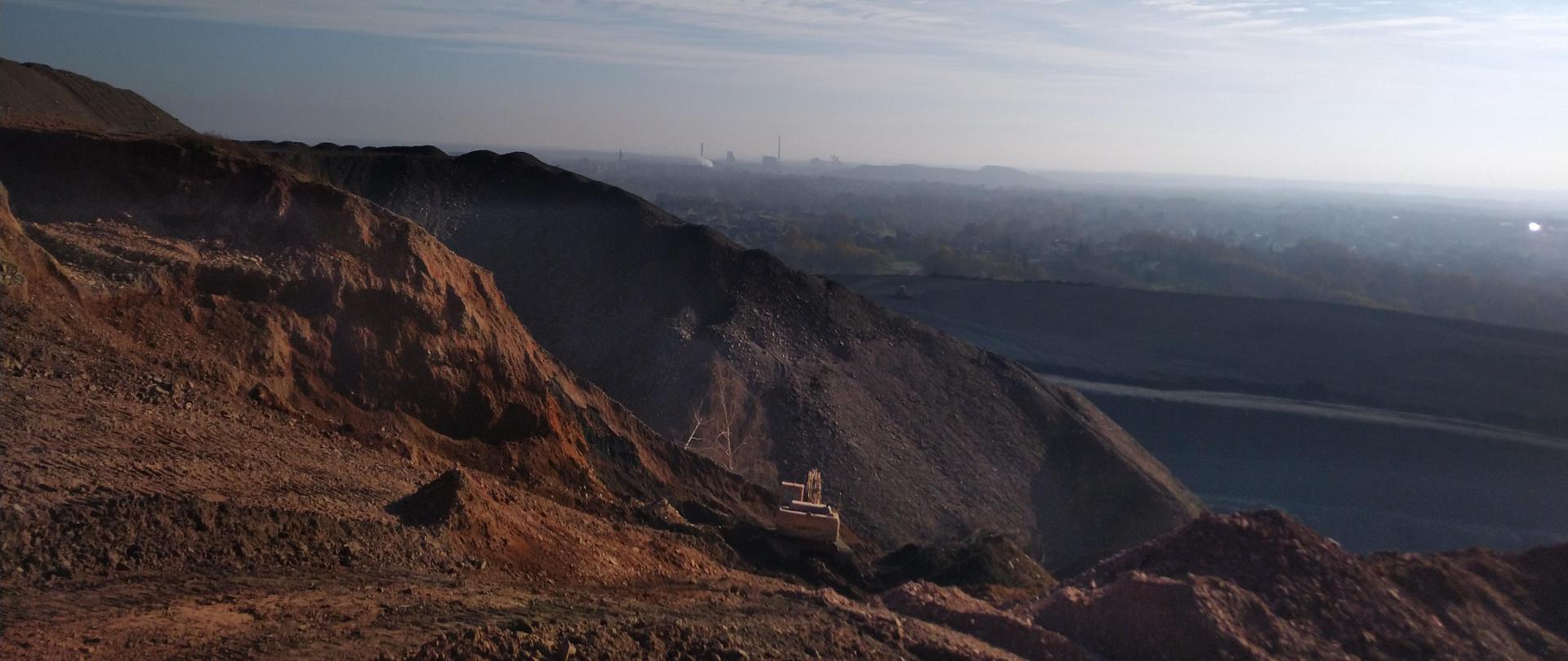 Szeroki plan, samotna koparka na tle panoramy miasta