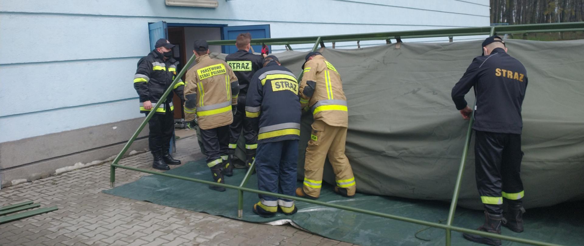 Strażacy rozstawiają namiot obok Hali Sportowej w Kazimierzy Wielkiej
