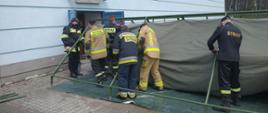 Strażacy rozstawiają namiot obok Hali Sportowej w Kazimierzy Wielkiej