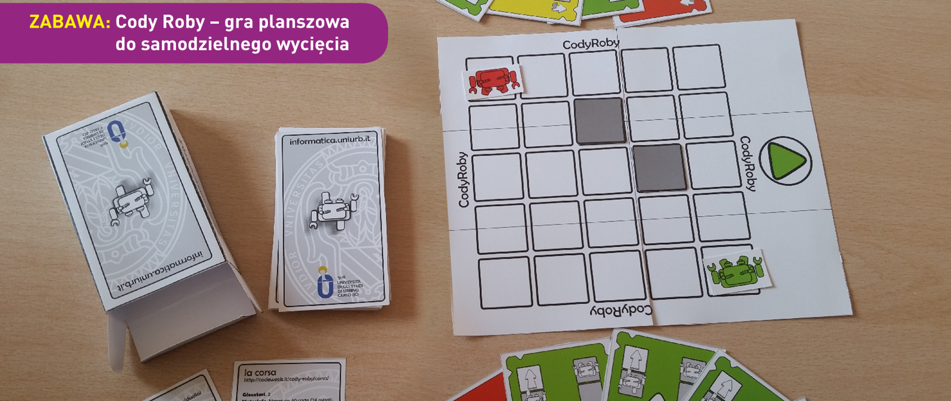 Zdjęcie pokazuje stół w czasie partii gry CodyRoby - widać karty, planszę i pudełko. U dołu znajduje się pasek logotypów: Europejskie Fundusze Polska Cyfrowa, Ministerstwo Cyfryzacji, NASK i Unia Europejska Europejski Fundusz Rozwoju Regionalnego.