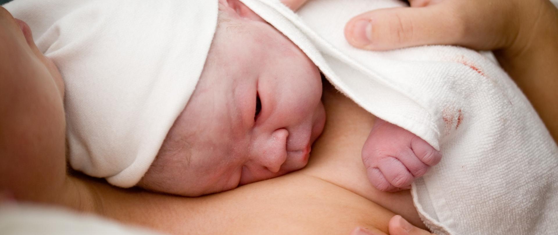 Matka skóra do skóry przytula nowonarodzone dziecko