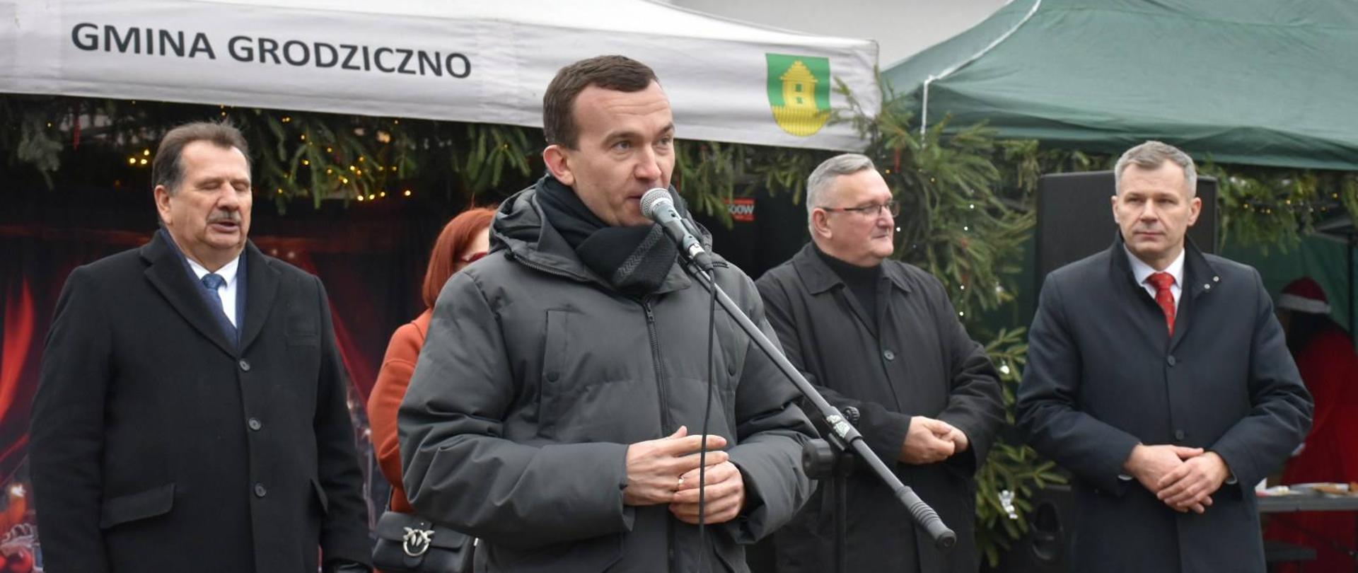 Mężczyzna przemawia na jarmarku świątecznym 