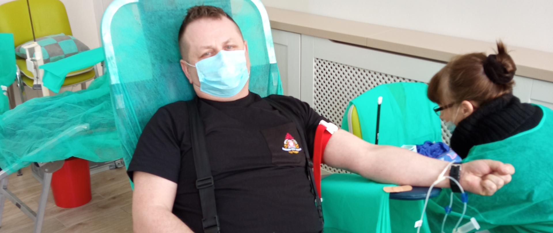 Zdjęcie przedstawia st. kpt. Bogdana Mielnika, który jest przygotowywany do honorowego oddania krwi