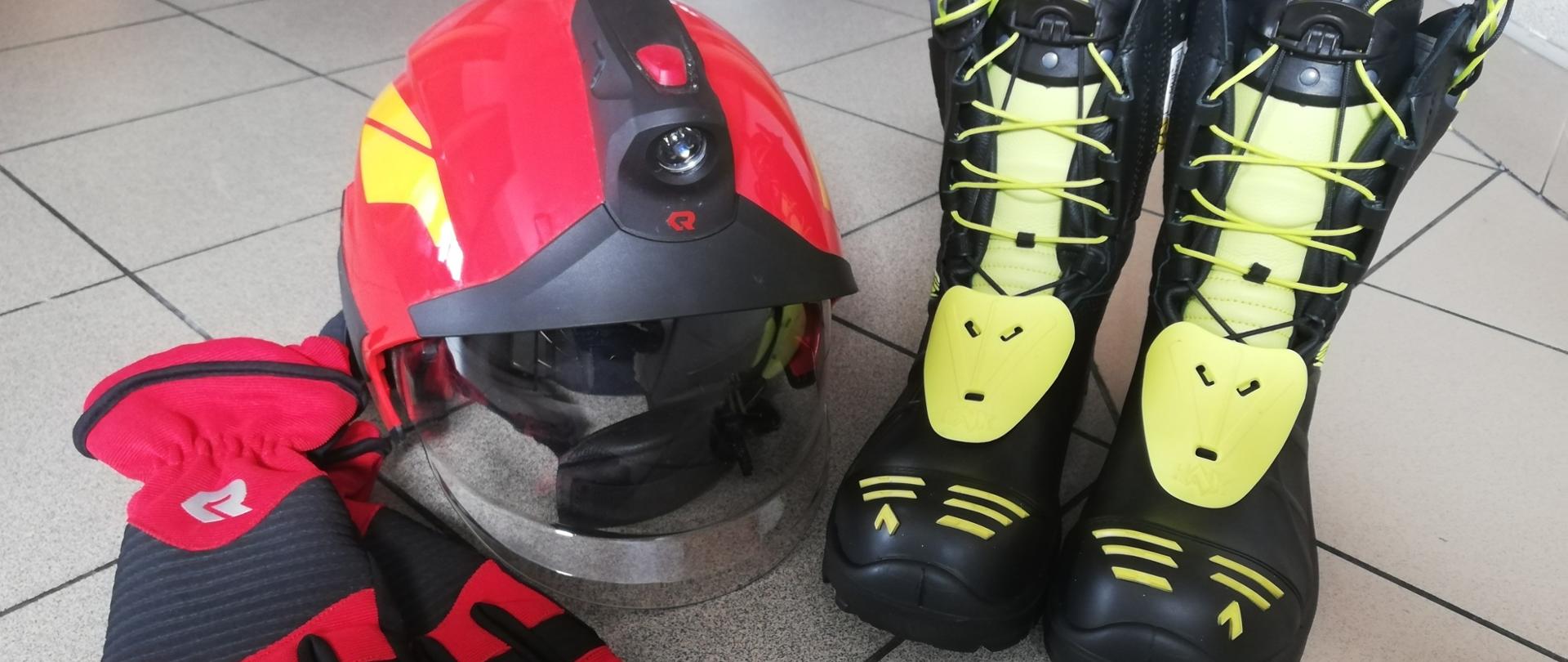 Zdjęcie przedstawia hełm, buty strażackie i rękawice techniczne