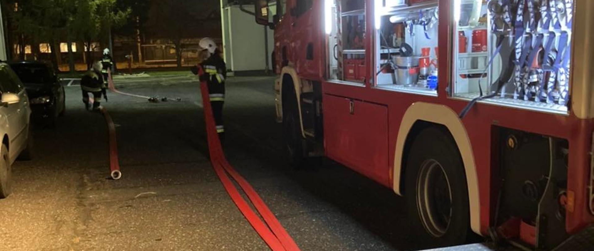  Kurs w ramach szkolenia podstawowego strażaków ratowników OSP w Komendzie Miejskiej PSP w Opolu. Strażak zwija wąż pożarniczy.