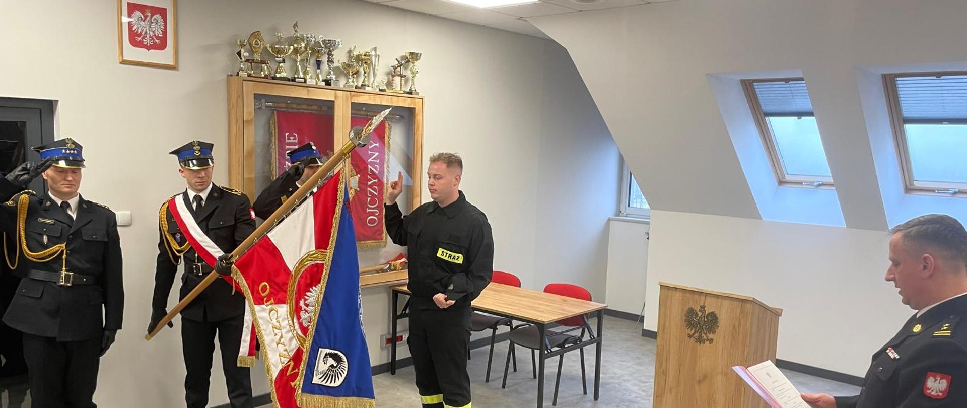 Na zdjęciu widoczny funkcjonariusz w trakcie składania ślubowania w obecności sztandaru Komendy.