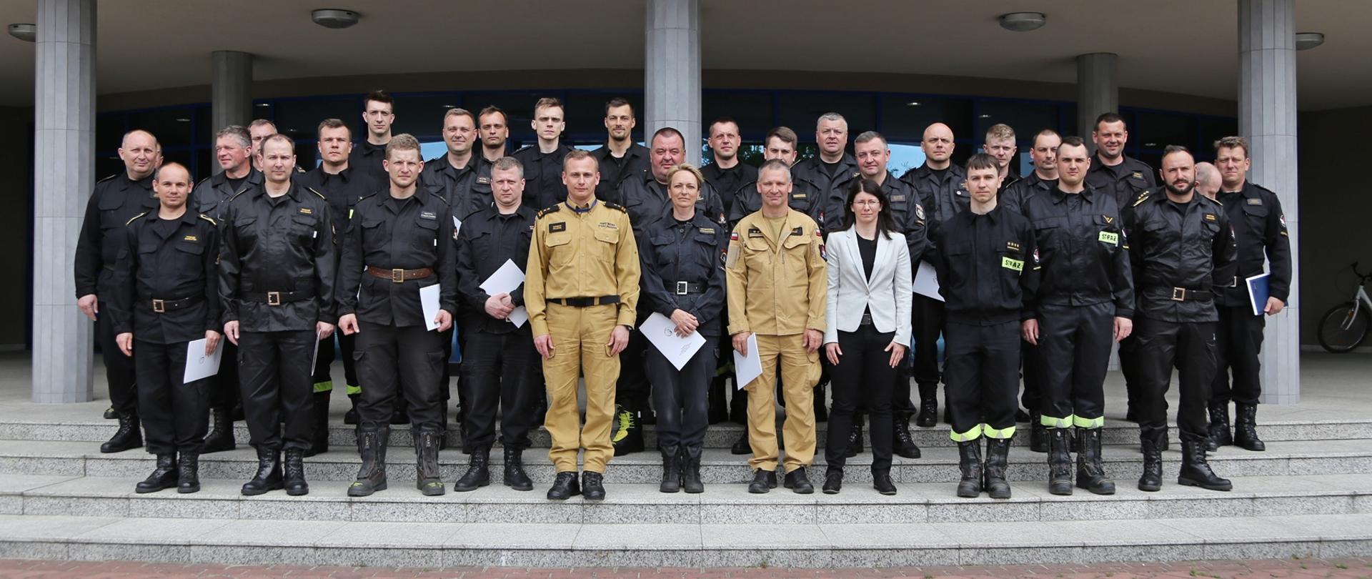 Grupowe zdjęcie uczestników warsztatów (26 osób) w towarzystwie Zastępcy Komendanta Centralnej Szkoły PSP oraz wykładowców (4 osoby)