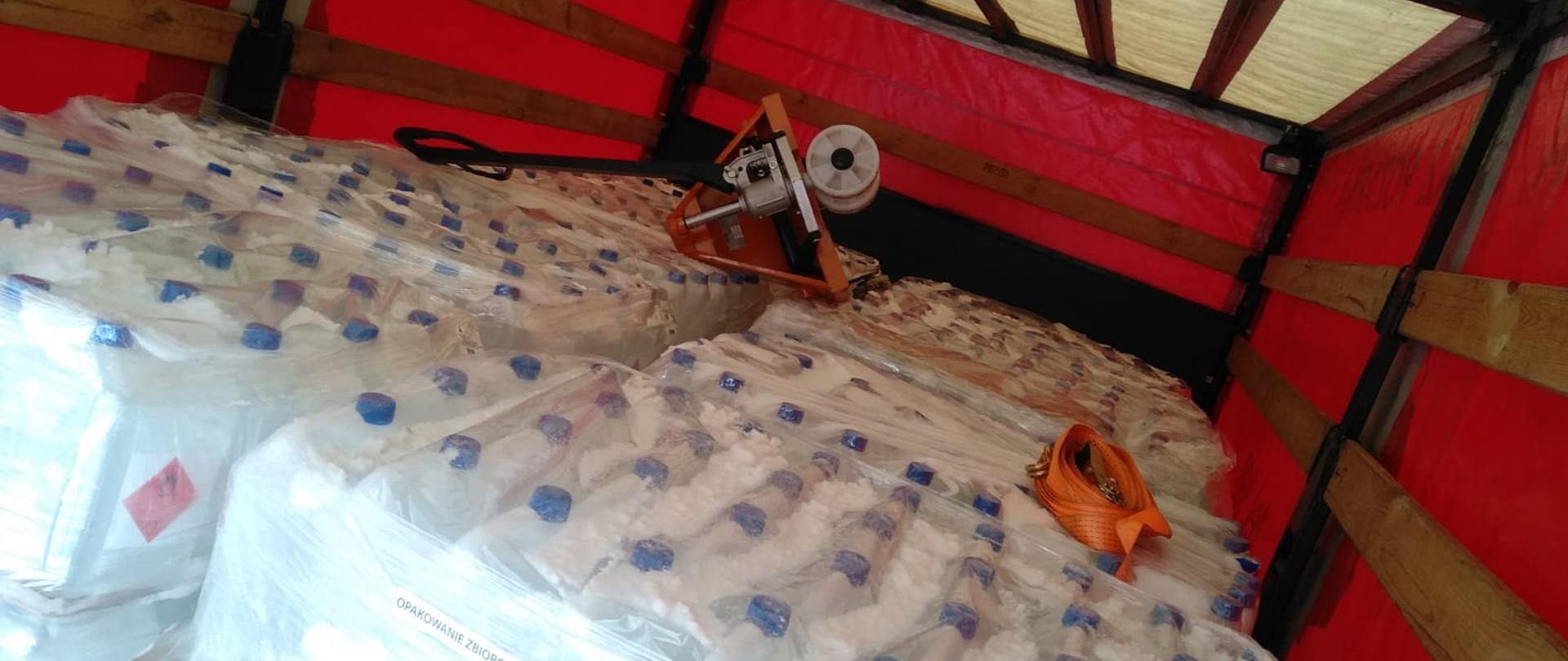 Wnętrze samochodu pożarniczego załadowanego środkami do dezynfekcji.