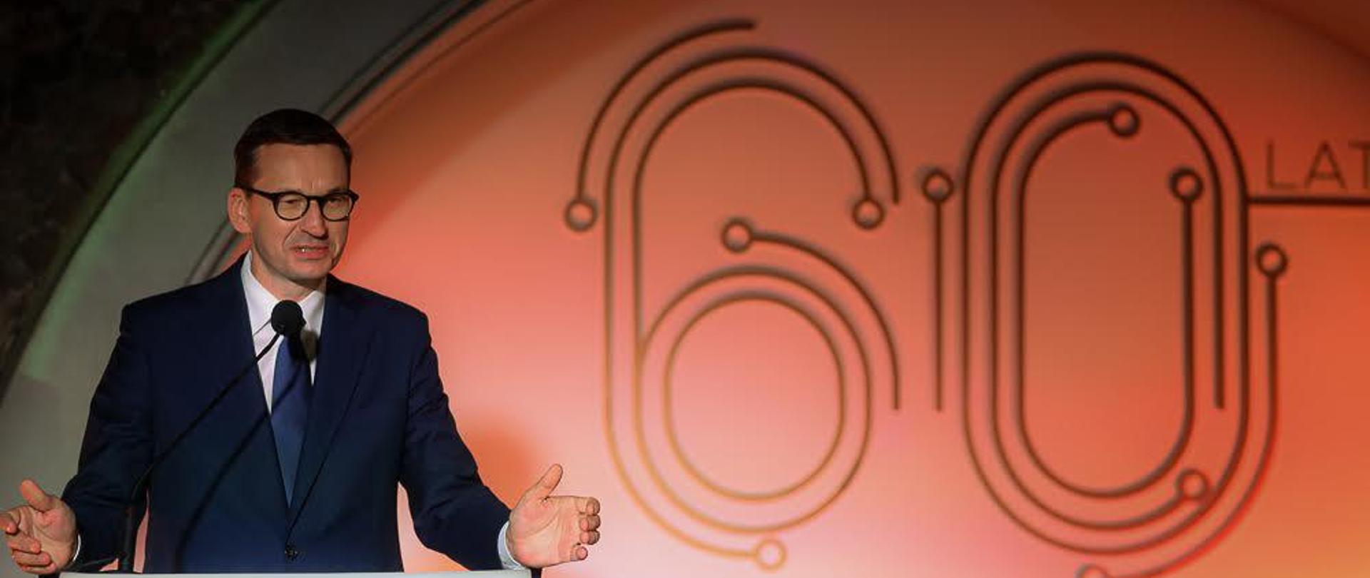 Premier przemawia na mównicy, w tle napis: 60 lat KGHM.