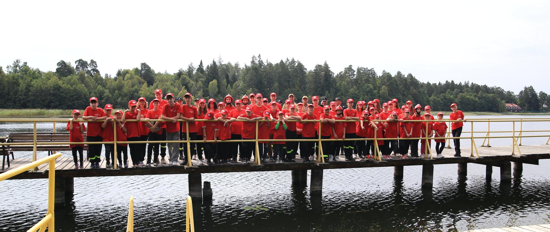 Zastępca Podlaskiego Komendanta Wojewódzkiego Państwowej Straży Pożarnej - st. bryg. Grzegorz Lisowski wizytował 20 sierpnia 2024 r. obóz MDP - zdjęcie grupowe kadry i młodzieży