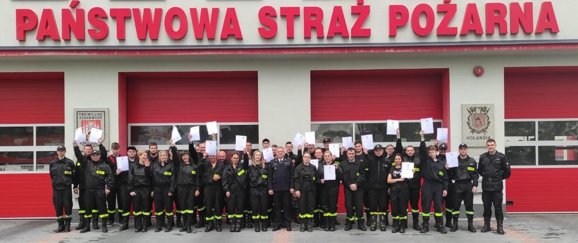 Na zdjęciu znajdują się druhowie OSP z jednostek powiatu chełmińskiego na wspólnym zdjęciu przed budynkiem komendy powiatowej. 