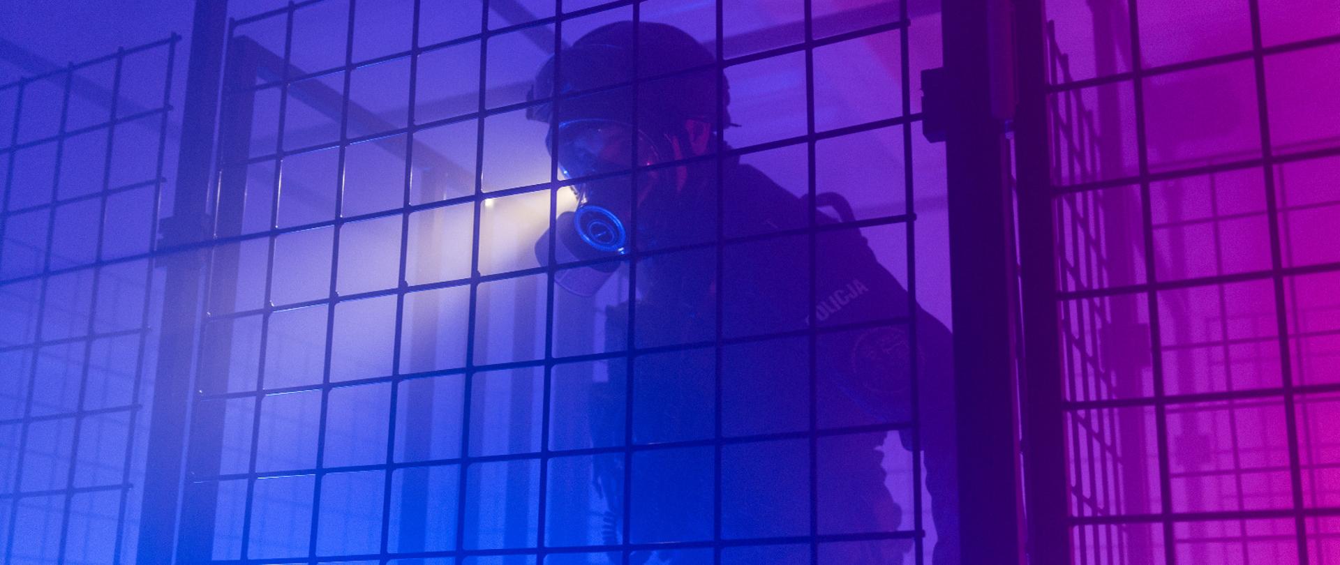 Zdjęcie przedstawia funkcjonariusza Policji podczas ćwiczenia w komorze dymowej. Panuje zadymienie.