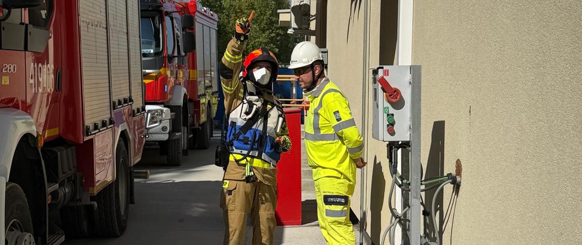 Na zdjęciu Kierujący Działaniem Ratowniczym, który rozmawia z kierownikiem zmiany, przekazującym kluczowe informacje o zdarzeniu. 