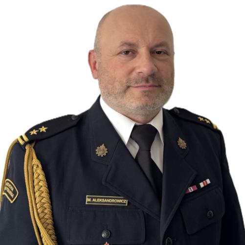 Na zdjęciu widać mężczyznę w ciemnym mundurze służbowym z odznaczeniami i pagonami. Stoi na jasnym tle i patrzy w stronę aparatu z neutralnym wyrazem twarzy.