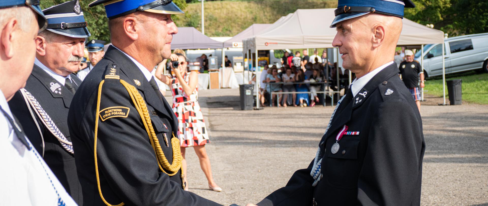 Zdjęcie przedstawia Zastępcę Podkarpackiego Komendanta Wojewódzkiego st. bryg. Janusza Jabłońskiego wraz ze strażakiem OSP otrzymującym wyróżnienie podczas uroczystości 140 lecia OSP Oleszyce