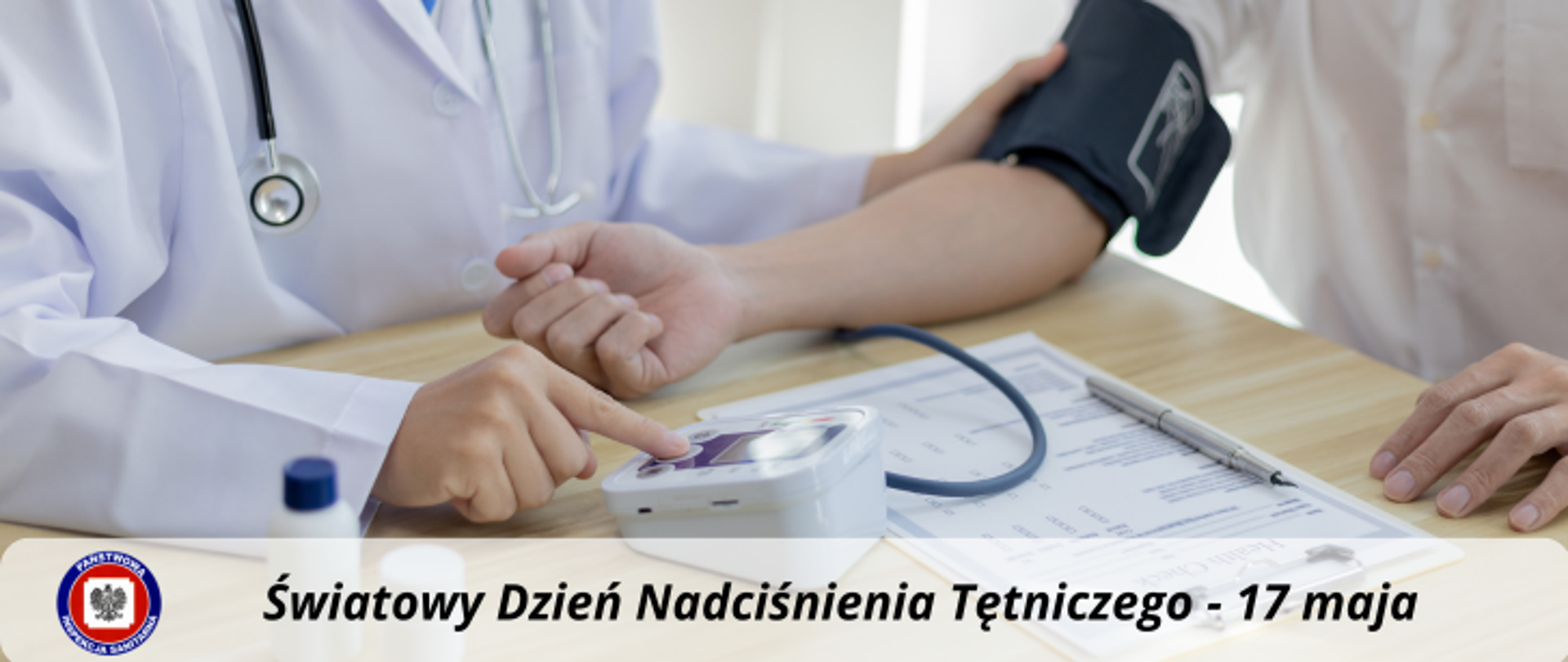 Pomiar ciśnienia w gabinecie lekarskim. Poniżej na jasnym, półprzezroczystym tle ciemny napis Światowy Dzień Nadciśnienia Tętniczego - 17 maja. Z jego lewej logo Państwowej Inspekcji Sanitarnej.