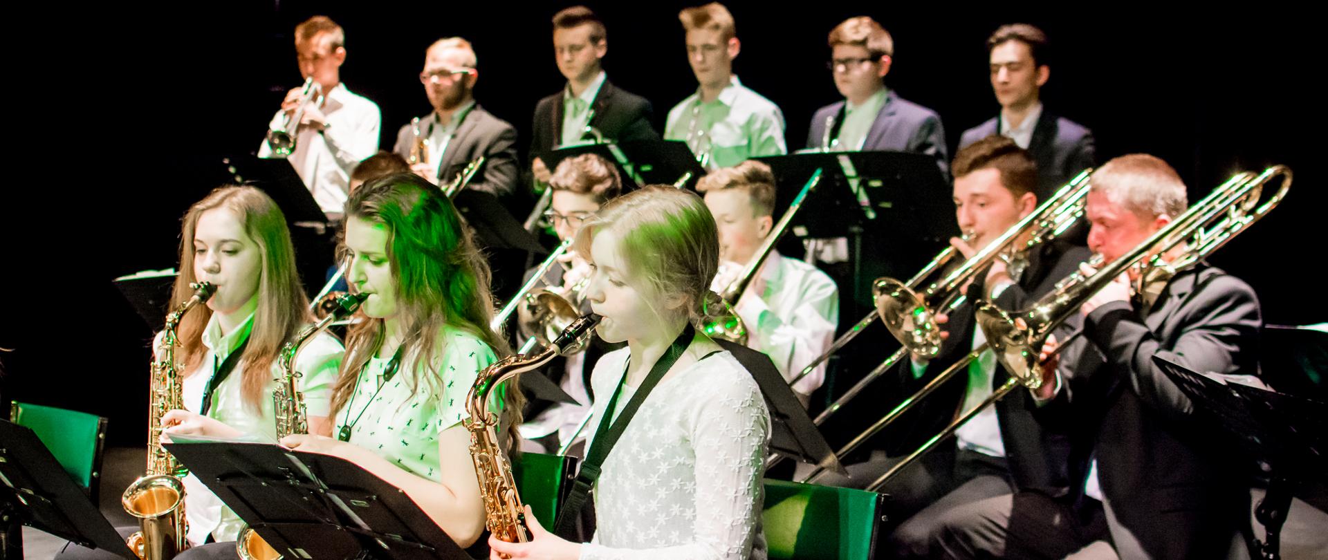 Uczniowie i absolwenci szkoły grający na instrumentach dętych podczas koncertu