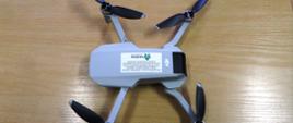 Na biurku leży dron z rozłożonymi skrzydłami. 