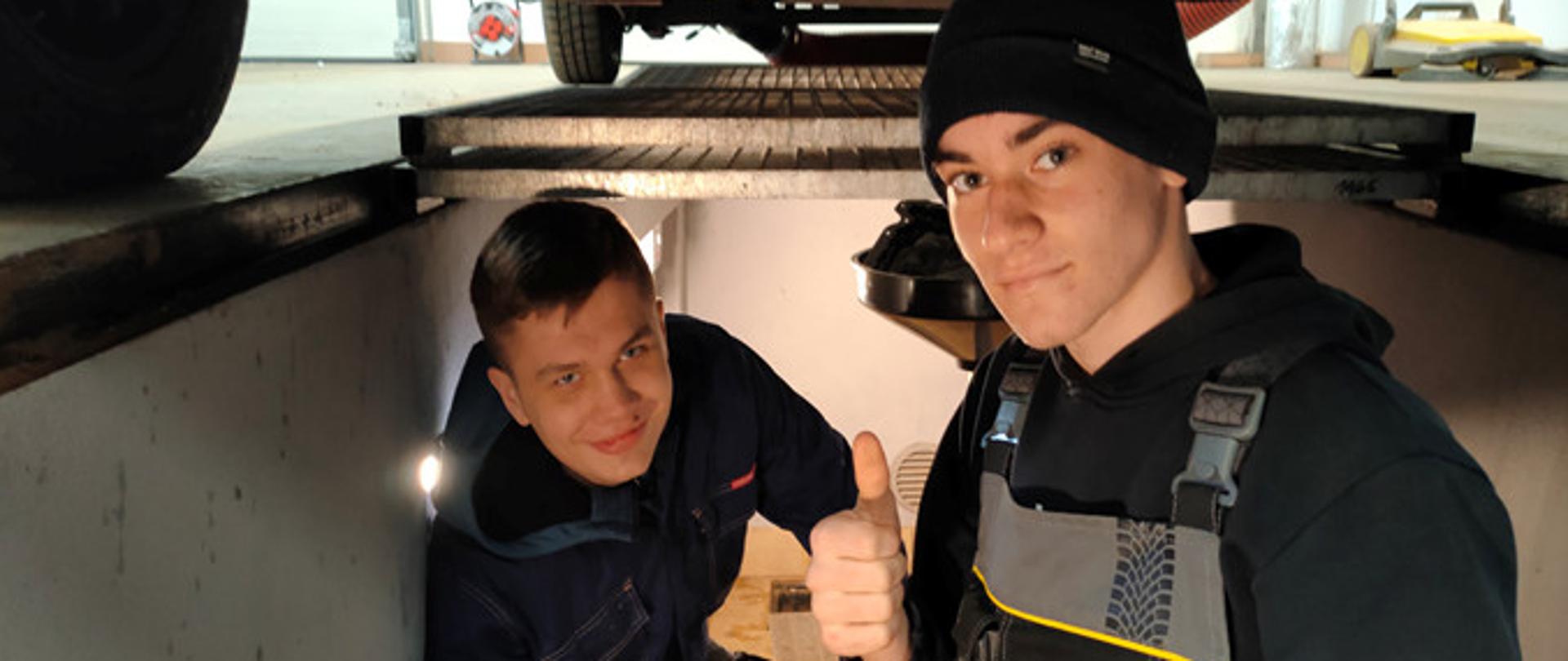 Uczniowie w kanale samochodowym podczas zajęć praktycznych 