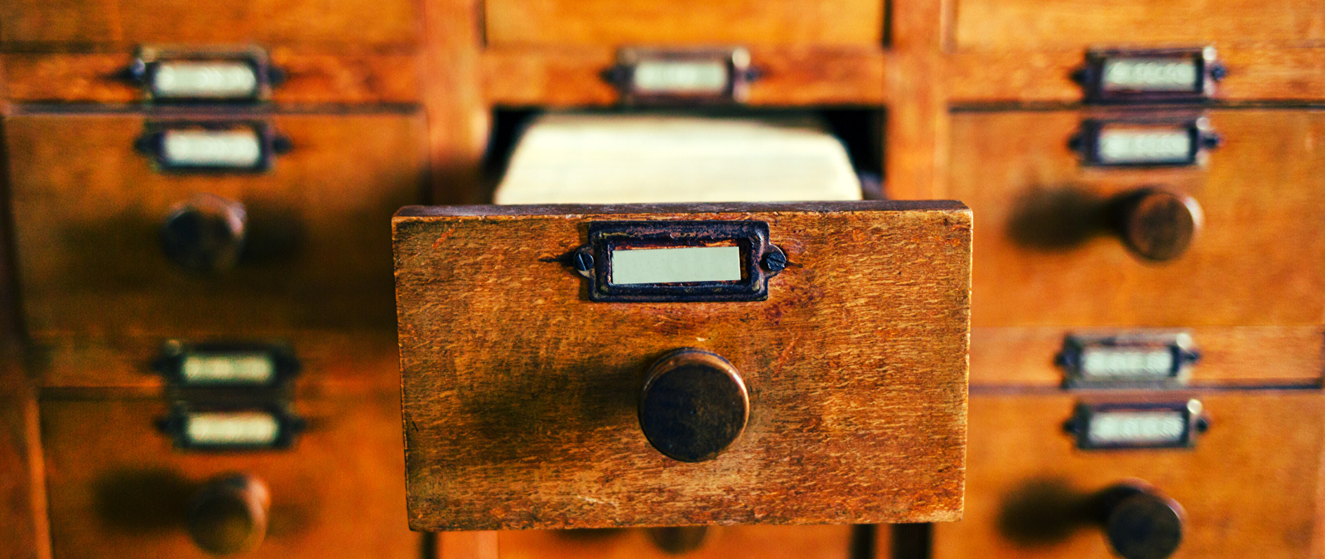 Biblioteczna szafka na karty katalogowe, jedna szuflada wysunięta.