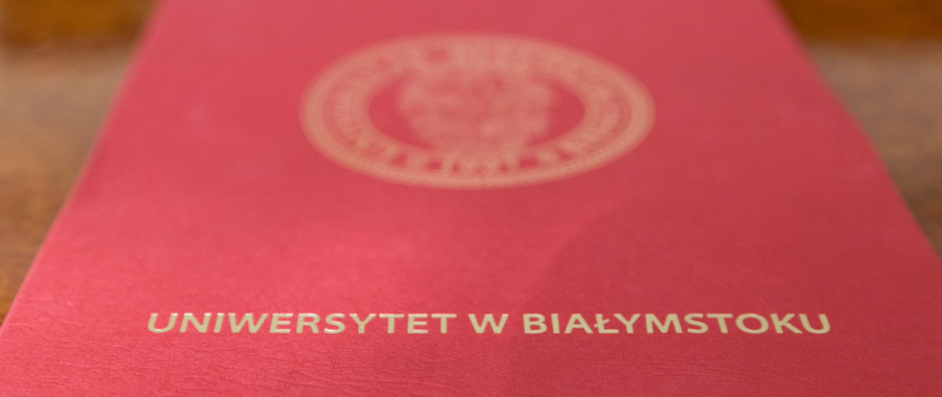 Czerwona teczka do dokumenty z napisem Uniwersytet w Białymstoku