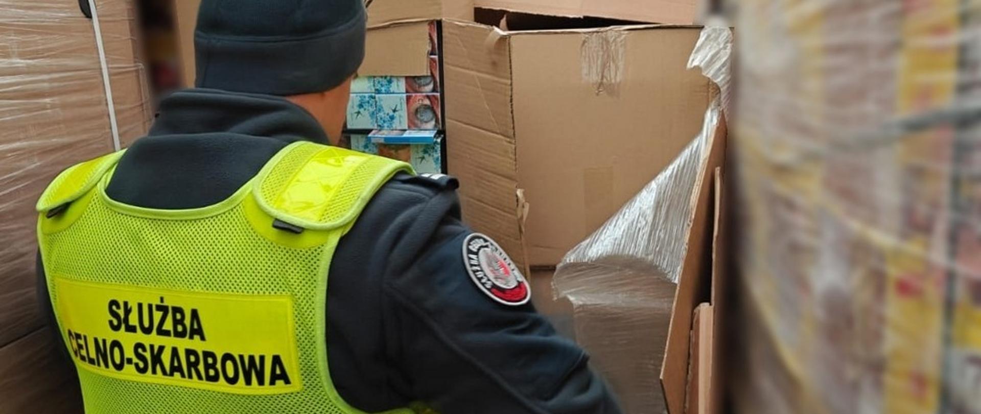 Funkcjonariusz przy kartonach z białoruskimi papierosami