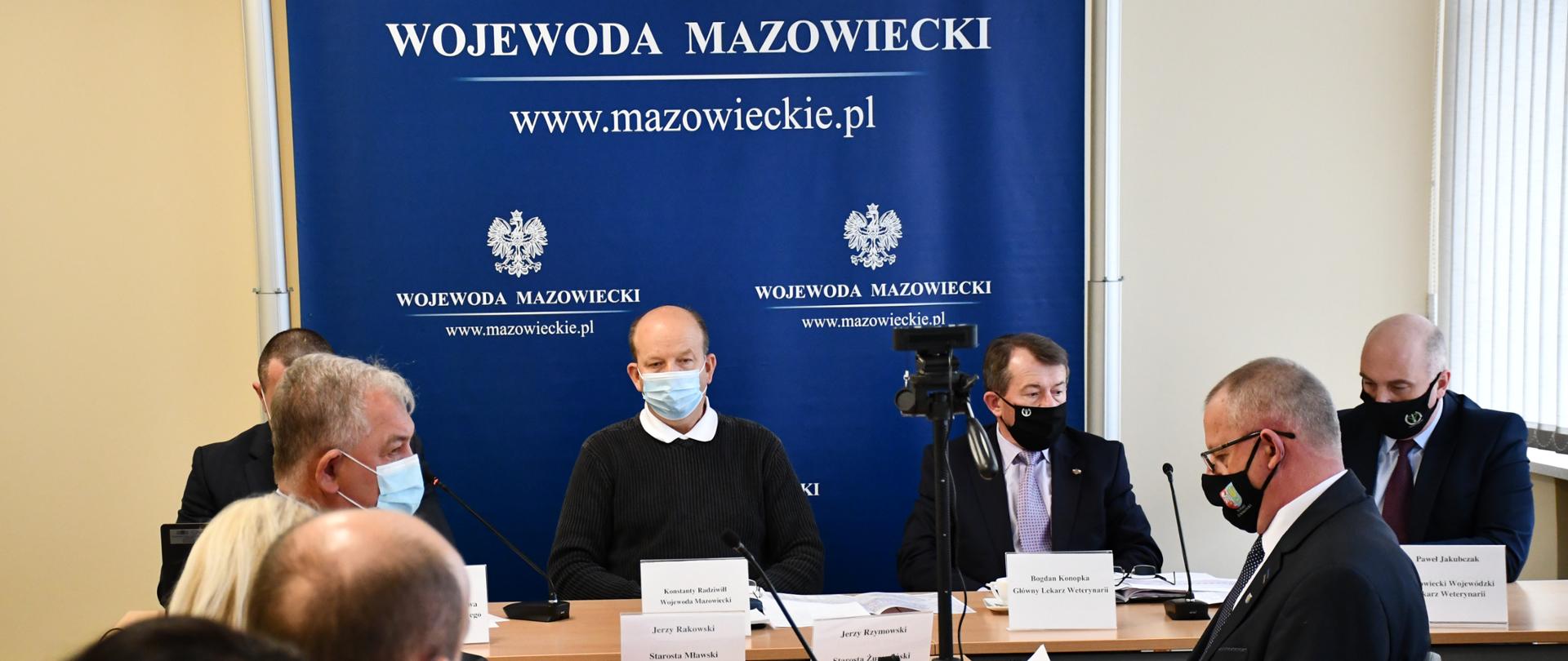 Posiedzenie MWZZK w Ciechanowie. Przy stole siedzi dziewięć osób, na wprost Wojewoda Mazowiecki na tle granatowej ścianki