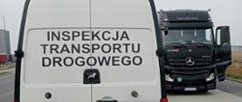 Na pierwszym planie pojazd Inspekcji Transportu Drogowego , za nim czarny pojazd ciężarowy podczas kontroli.