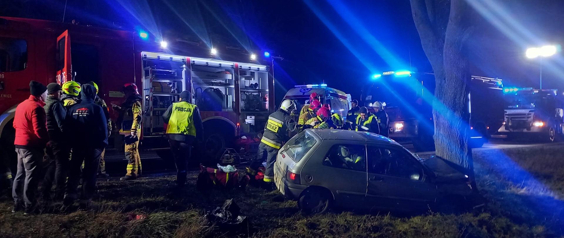Działające służby ratownicze przy roztrzaskanym pojeździe