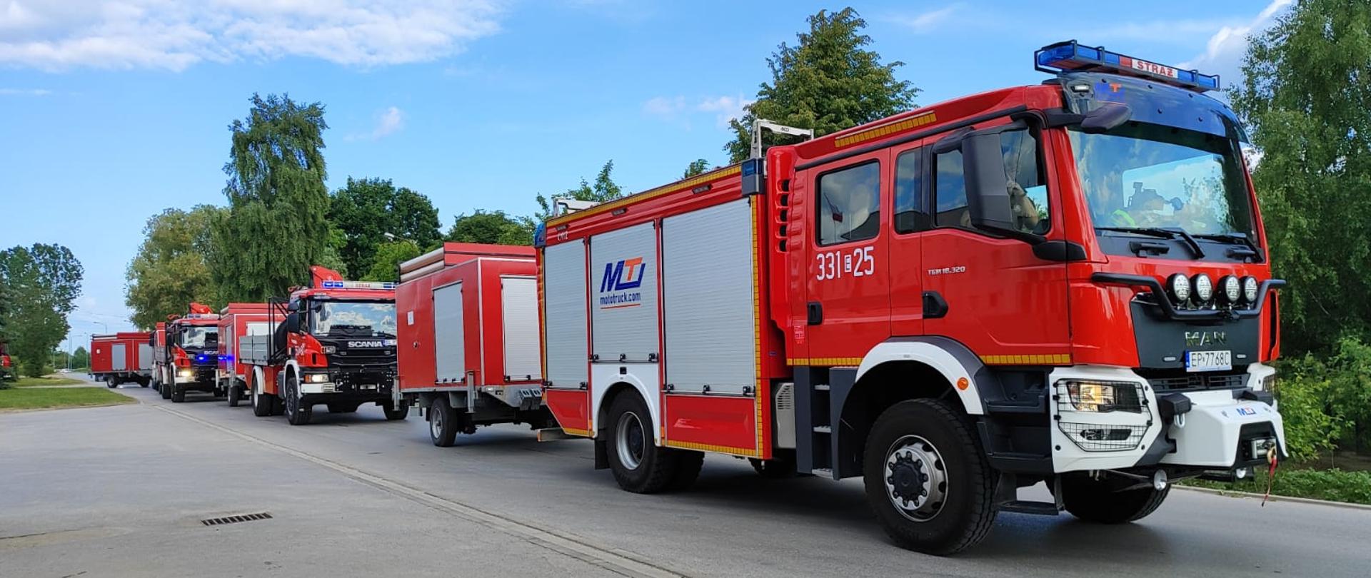 kolumna samochodów strażackich z przyczepami na drodze