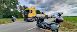 Stojące na drodze trzy ciężarówki. Obok stoją dwa motocykle służbowe ITD.