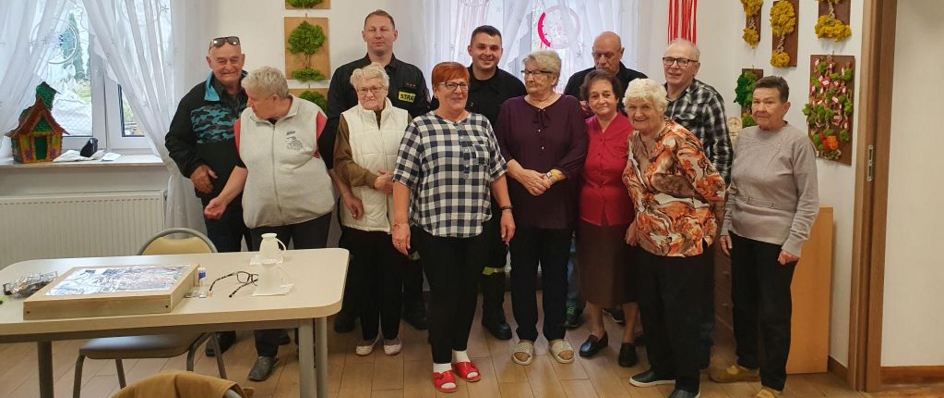 Na zdjęciu widać dwóch funkcjonariuszy PSP w towarzystwie seniorów z dziennego domu "Senior+" w Ustrzykach Dolnych.