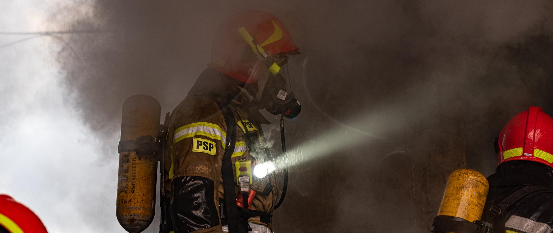 Na zdjęciu widać trzech strażaków podczas akcji gaśniczej