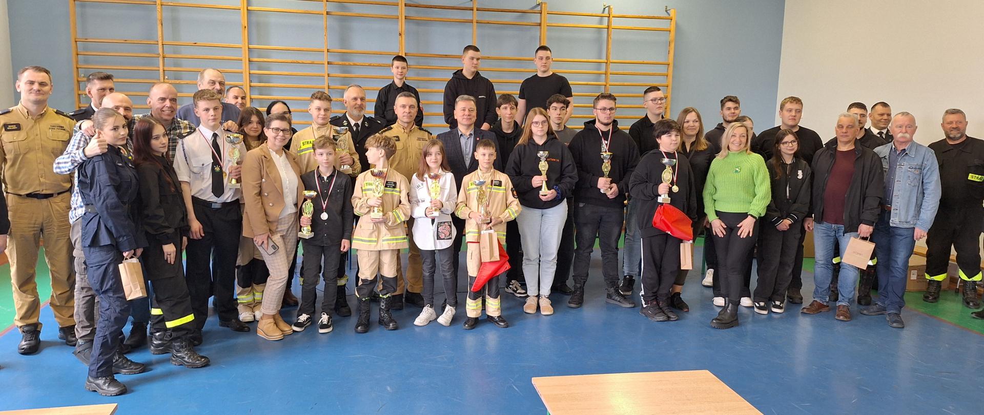 Zdjęcie przedstawia uczestników turnieju, komisję oraz opiekunów podczas wręczenia wyróżnień. 