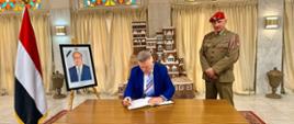 Ambasador RP Robert Rostek (po lewo) dokonuje wpisu w księdze kondolencyjnej. Towarzysz mu attaché obrony pułkownik Artur Rochnowski (po prawo).