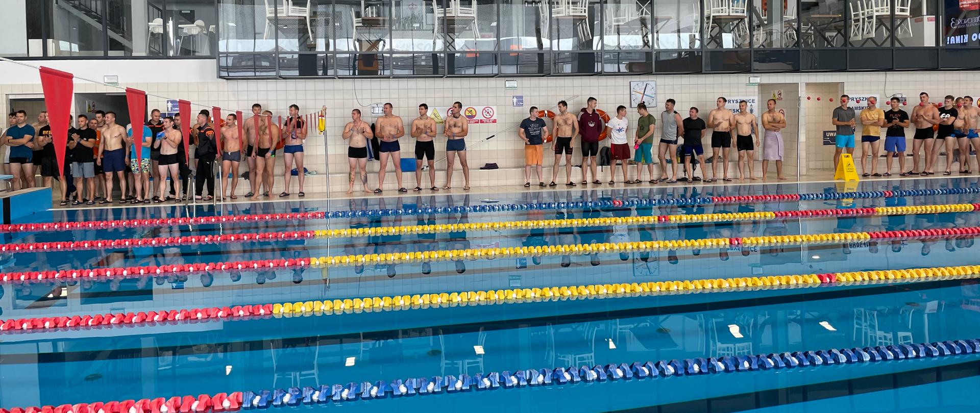 na zdjęciu widok torów basenu i zawodnicy stojący na otwarciu 