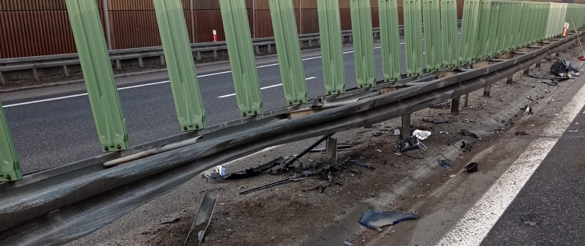 Na zdjęciu widoczne są bariery ochronne rozdzielające pasy ruchu na drodze ekspresowej uszkodzone w wyniku uderzenia w nie samochodu osobowego.