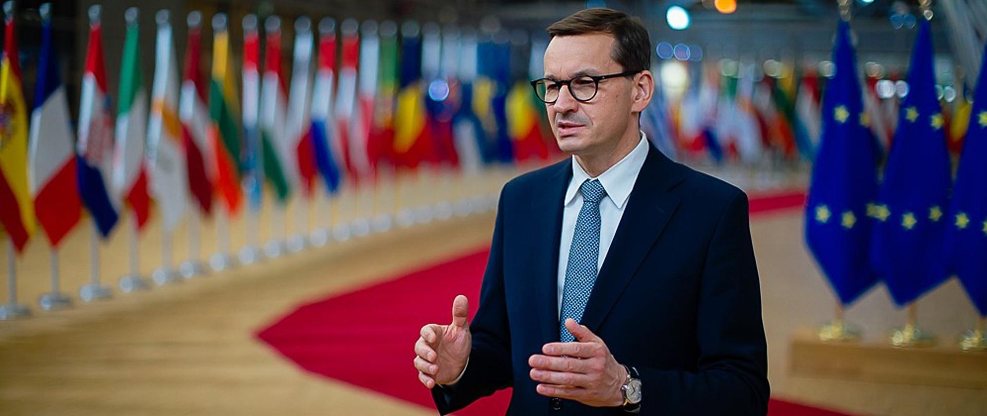 Premier na tle flag europejskich.