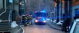 Strażacy i samochód pożarniczy na obiekcie hotelu
