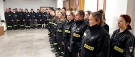 Na zdjęciu strażacy z Ochotniczych Straży Pożarnych po egzaminie kończącym szkolenie podstawowe strażaków ratowników OSP w sali konferencyjnej w Komendzie Powiatowej Państwowej Straży Pożarnej w Gorlicach podczas uroczystego wręczenia zaświadczeń. Strażacy ubrani w ubrania koszarowe koloru czarnego bez czapek.