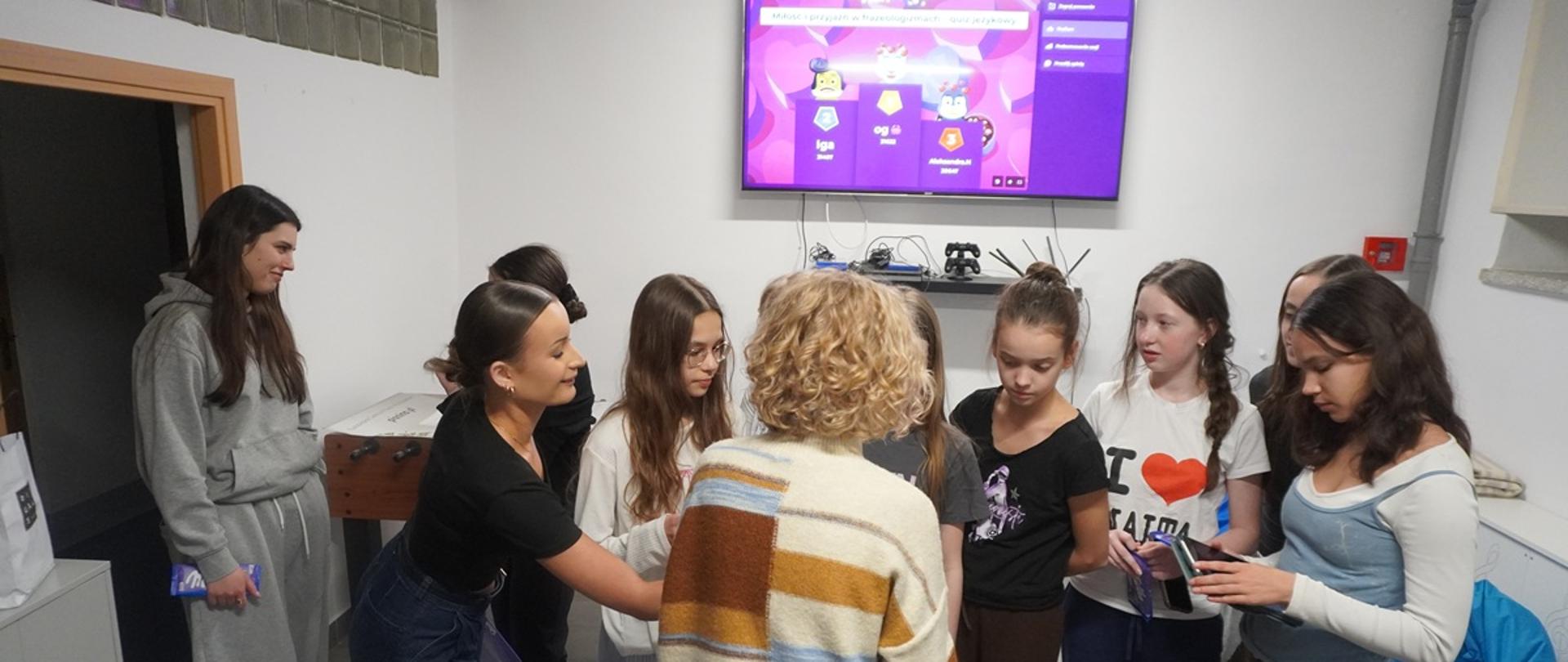 Wychowawczyni przekazuje słodkie upominki uczestnikom biorącym udział w quizie.