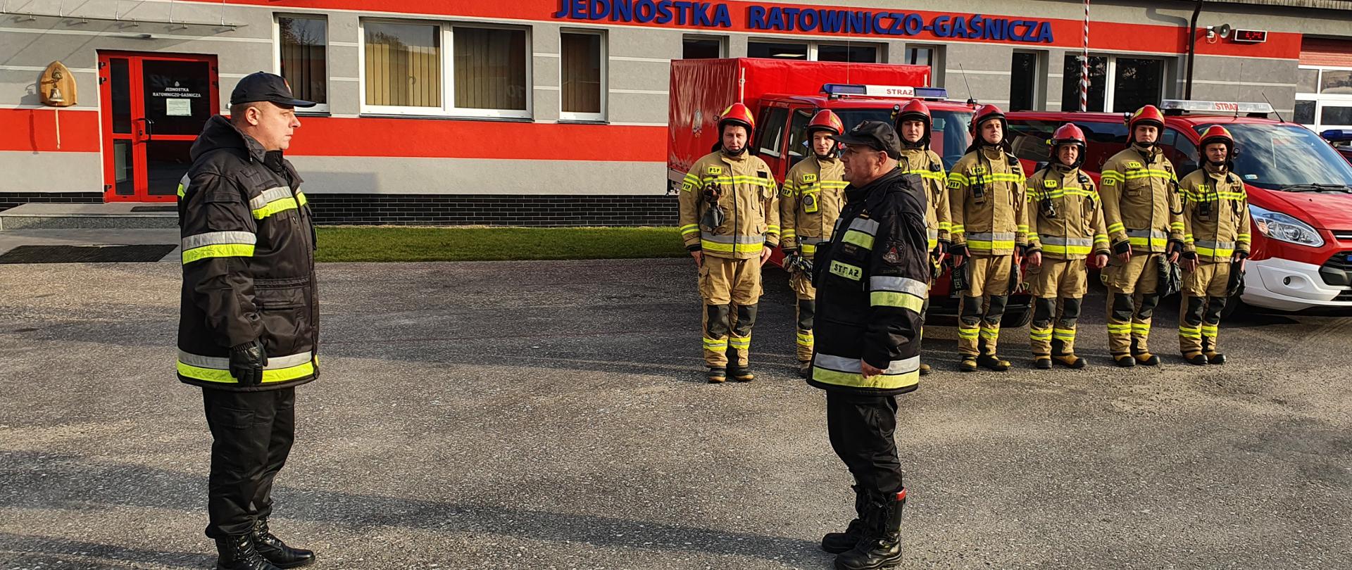 Na zdjęciu Dowódca Jednostki składa meldunek Komendantowi Powiatowemu w tle zmiana służbowa oraz budynki JRG.
