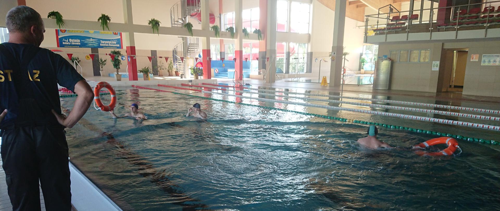 Strażacy JRG Limanowa podczas ćwiczeń technik ratownictwa wodnego na Pływalni Limanowskiej