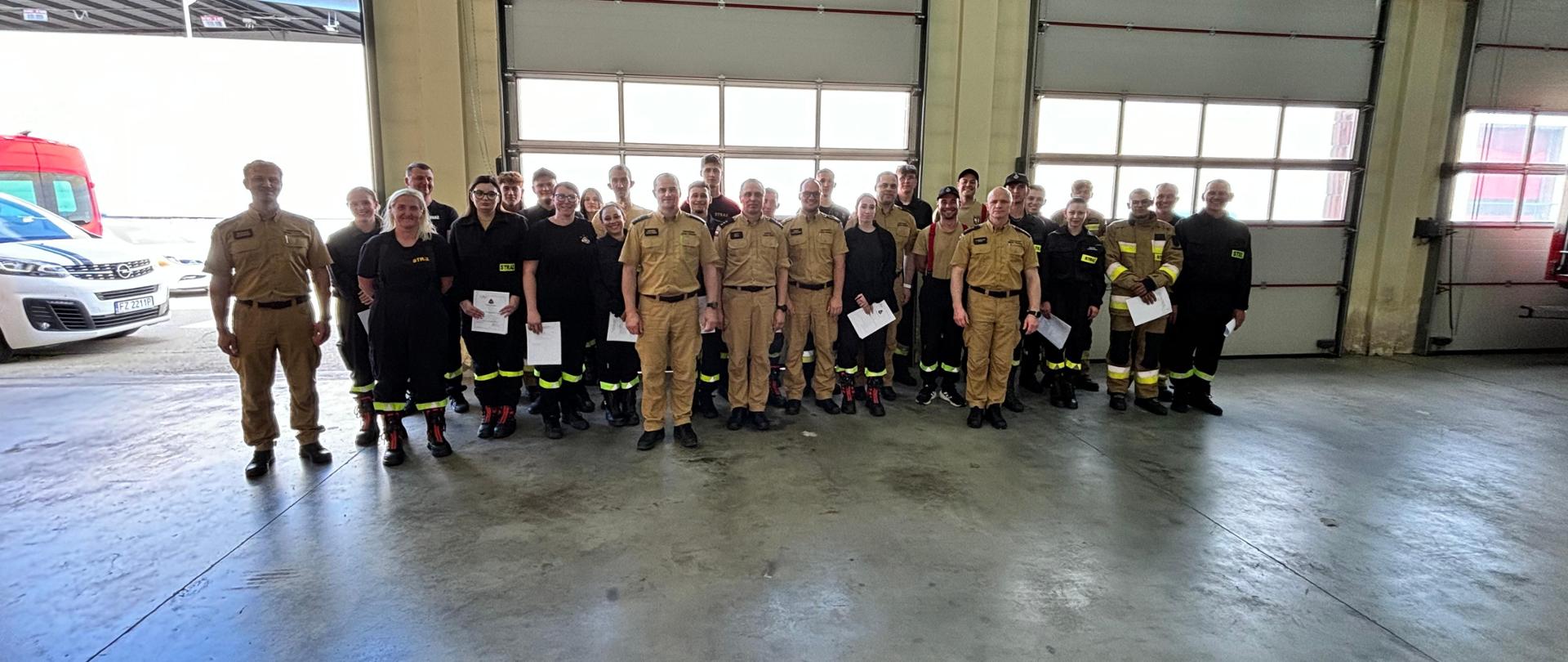 Strażacy stoją w szyku po zakończonym egzaminie.