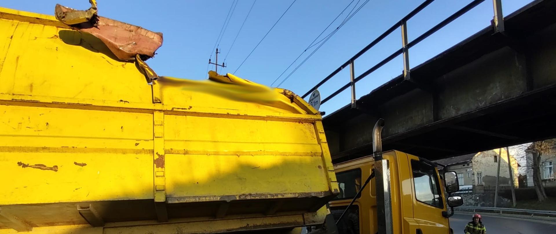 Widok uszkodzonego samochodu oraz wiaduktu.