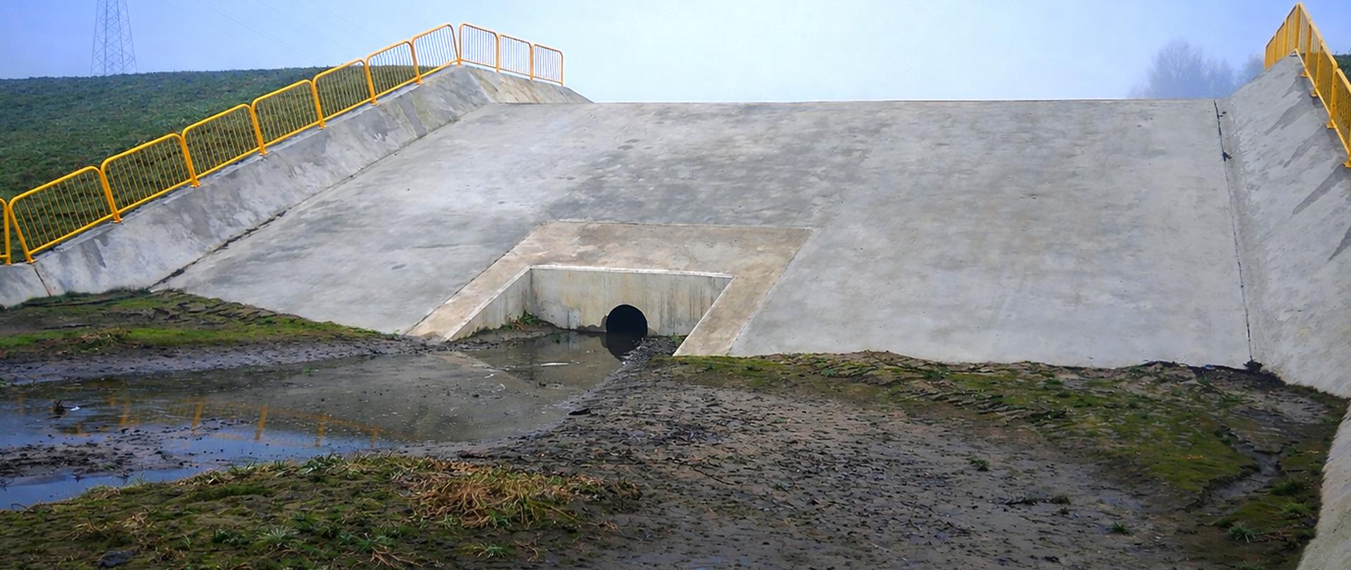 Suchy zbiornik przeciwpowodziowy na potoku Tusznica w gminie Kłaj. Widoczna czasza zbiornika oraz elementy zapory ziemnej.