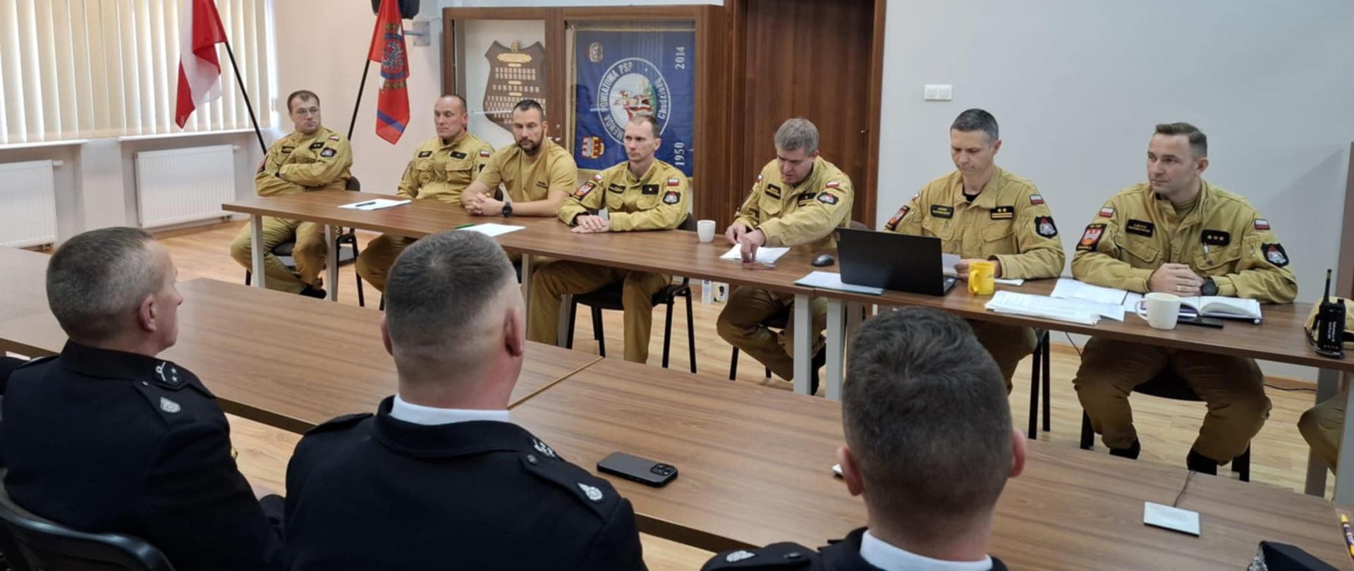 Zdjęcie przedstawia strażaków podczas spotkania w siedzibie Komendy Powiatowej Państwowej Straży Pożarnej w Chodzieży.
W tle świetlica.
