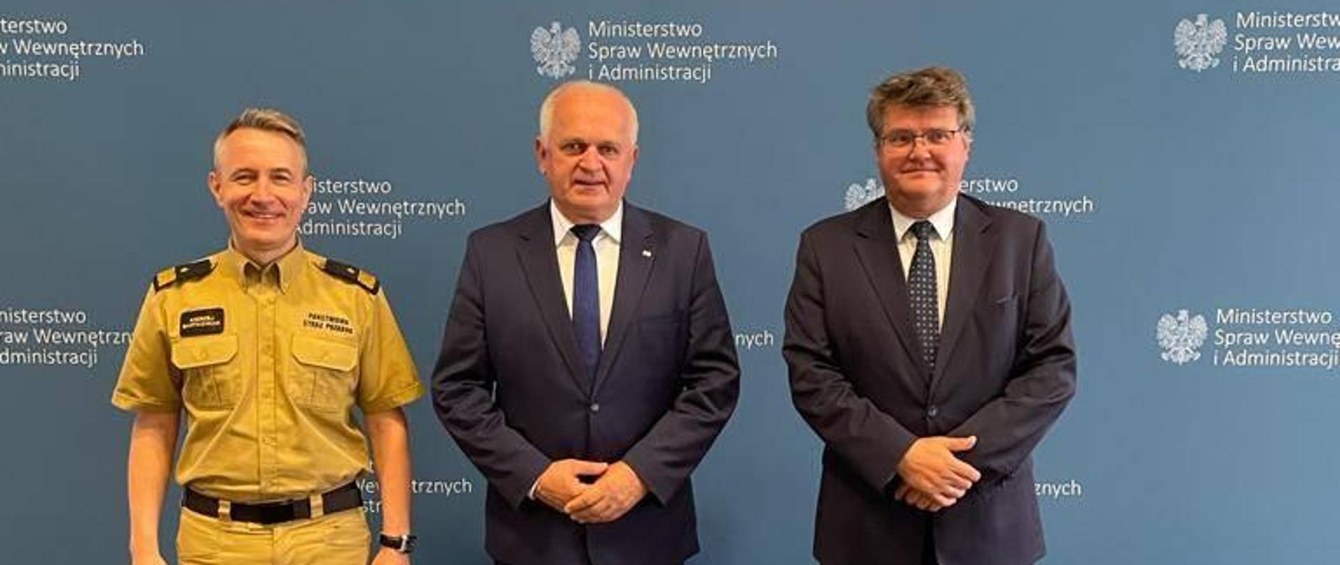 Na tle ścianki promocyjnej Ministerstwa Spraw Wewnętrznych i Administracji stoją (od lewej) nadbryg. Andrzej Bartkowiak, wojewoda Władysław Dajczak i sekretarz stanu Maciej Wąsik 