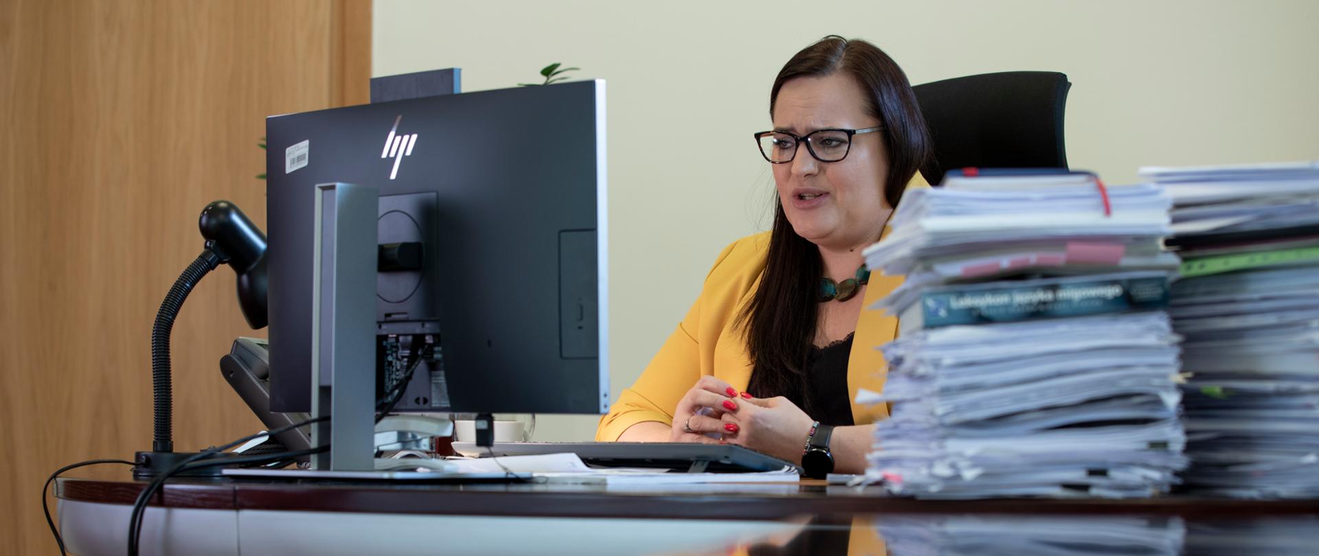 Wiceminister Małgorzata Jarosińska-Jedynak siedzi przy biurku przed monitorem