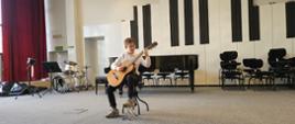 Chłopiec gra na gitarze.